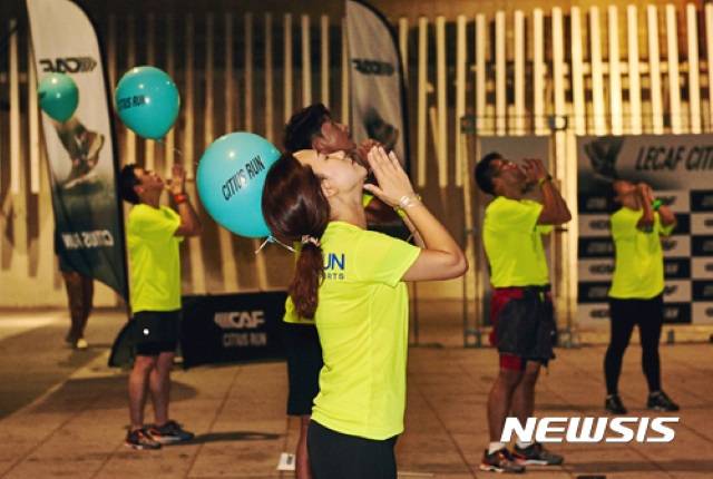 마라톤 열풍을 이끌고 있는 젊은 세대는 혼자 뛰지 않는다. 친목과 이성교제, 자기표현이 달리기와 함께 이뤄지고 있다. 한 코미디 프로그램이 이런 문화를 다루기도 했다. 사진은 늦은 시간 여의도에서 열린 한 이벤트에서 참가자들이 준비운동을 하는 모습. / 뉴시스