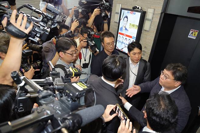 김건희 여사의 의혹들을 수사하는 민중기 특별검사팀이 18일 서울 여의도 국민의힘 중앙당사에 대한 '통일교 집단 입당' 의혹과 관련한 압수수색에 나섰다. 당사에 도착한 특검팀이 당사에 진입하기 위해 국민의힘 측 변호사에게 수색영장을 제시하며 실랑이를 벌이고 있다./남강호 기자