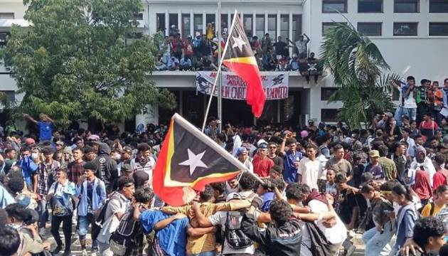 지난 17일(현지시간) 동티모르 딜리 국회의사당 밖에서 국회의원들에게 종신연금과 새 차량을 지급하기로 한 결정을 취소할 것을 요구하는 시위에서 대학생들이 동티모르 국기와 현수막을 들고 있다. [사진=로이터/연합뉴스]