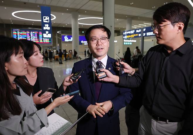 South Korean Trade Minister Yeo Han-koo (center) answers reporters' questions upon arriving at Incheon Airport on Friday. (Yonhap)