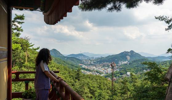 A participant gazes out over central Seoul from Geumsun Temple on Aug. 27. The temple offers panoramic views of the city. [BAEK JONG-HYUN]