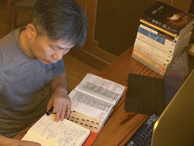 최 원장이 컴퓨터 앞에서 성경책을 읽으며 다음날 묵상글을 적고 있는 모습. 최 원장 제공