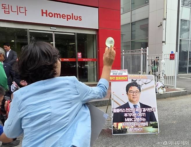 (천안=뉴스1) 이시우 기자 = 마트 노동자들이 2일 천안시 동남구 홈플러스 천안점 앞에서 열린 폐점 반대 기자회견에서 김병주 MBK파트너스 회장을 규탄하며 얼굴 사진에 물풍선을 던지고 있다. 2025.6.2/뉴스1  Copyright (C) 뉴스1. All rights reserved. 무단 전재 및 재배포,  AI학습 이용 금지. /사진=(천안=뉴스1) 이시우 기자