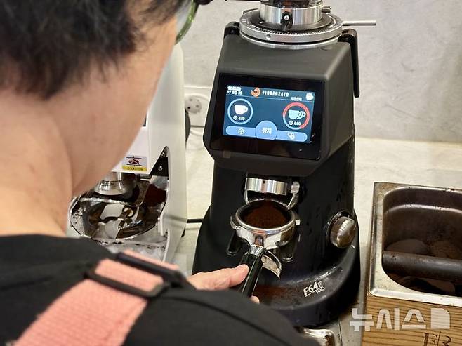 [서울=뉴시스] 한이재 기자 = 17일 오전 서울 마포구에 있는 누구나 카페에서 김장자씨가 포터 필터에 분쇄된 원두를 담고 있다. 2025.09.18. nowone@newsis.com