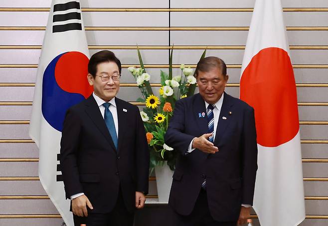 이재명 대통령이 8월 23일(현지 시간) 일본 도쿄 총리 관저에서 이시바 시게루 일본 총리와 한일 확대 정상회담 기념촬영을 마치고 자리 안내를 받고 있는 모습. 뉴시스