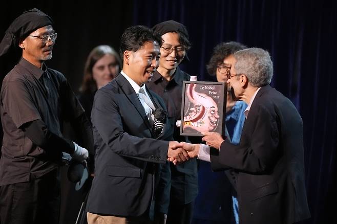 ‘줄무늬 소’ 연구를 주도한 고지마 도모키 박사(가운데)가 18일(현지시간) 미국 보스턴에서 열린 이그노벨상 시상식에서 상을 받고 있다. AP 연합뉴스
