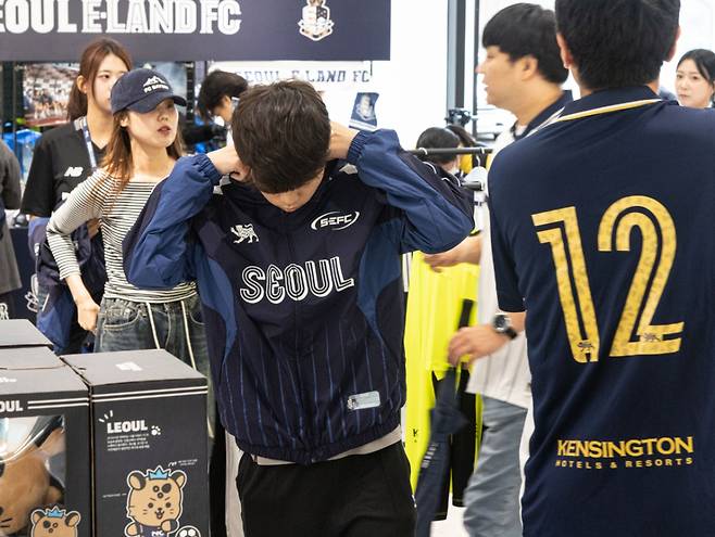 한정판 바람막이를 입어보는 팬의 모습. /사진=서울이랜드 제공