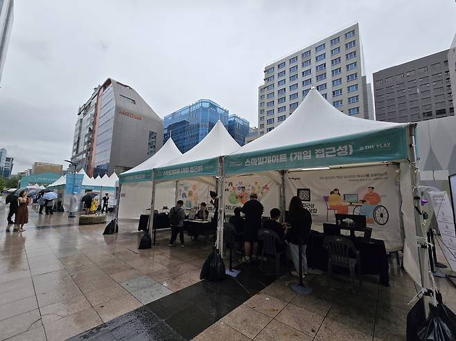 스마일게이트의 게임 접근성 부스     (성남=연합뉴스) 김주환 기자 = 도심형 게임문화 축제 'GXG 2025'가 열린 19일 경기 성남시 판교역 인근 거리에 스마일게이트의 게임 접근성 기기 체험 부스가 설치돼있다. 2025.9.19 jujuk@yna.co.kr