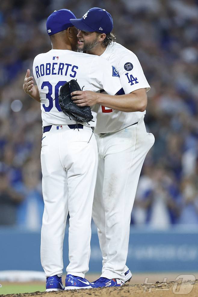 다저스 커쇼(오른쪽)가 정규시즌 마지막 홈 등판을 마친 뒤 로버츠 감독과 포옹하고 있다. ⓒ AFP=뉴스1