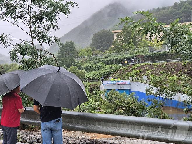 강원 강릉에 또 다시 단비가 내린 20일 오후 강릉 성산면 오봉리 한국수력원자력 강릉수력발전소에서 예정된 도암댐 도수관로 저류수 방류를 보기 위한 주민과 시 관계자들은 우산을 쓰고 현장을 바라보고 있다. 2025.9.20/뉴스1 ⓒ News1 윤왕근 기자