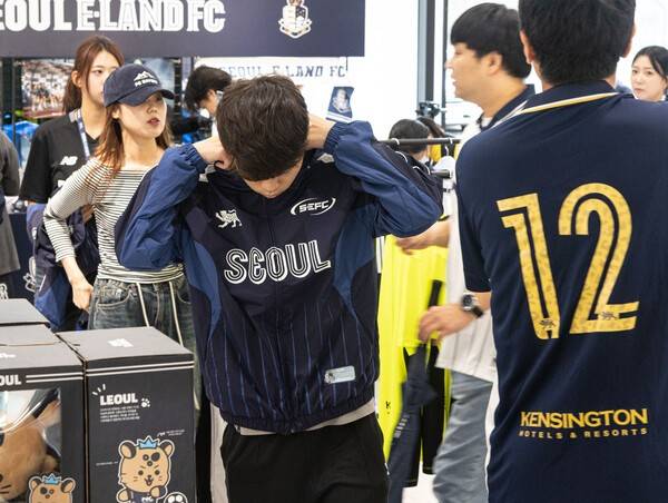 19일 서울 성동구 무신사 스페이스 성수3에서 프로축구 서울 이랜드와 온라인 패션 편집숍 무신사의 'One Drop, One Moment(원 드롭, 원 모먼트)' 팝업스토어가 열렸다. 팝업스토어 방문한 고객이 한정판 협업 의류를 입어보고 있다. /사진=서울 이랜드 제공