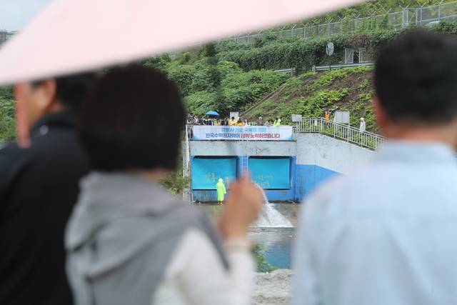 20일 강원 강릉시 성산면 남대천 상류에서 시민들이 도암댐 비상 방류를 지켜보고 있다.     도암댐 방류는 2001년 수질 문제 등으로 중단된 이후 24년 만이다.  연합뉴스