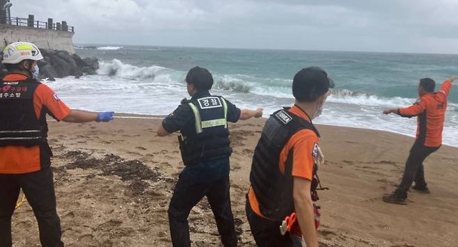 119구조대가 김양재 경사의 서핑 보드에 로프를 건내 끌어 당기는 모습 (제주경찰청 제공)