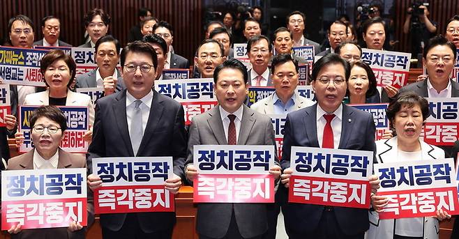 장동혁 대표(앞줄 가운데)를 비롯한 국민의힘 의원들이 19일 의원총회에서 피켓을 들고 더불어민주당을 규탄하고 있다. [사진 = 뉴스1]