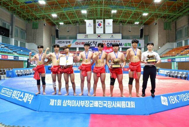 20일 강원특별자치도 삼척시 삼척체육관에서 열린 ‘제1회 삼척이사부장군배전국장사씨름대회' 중학부 단체전 우승을 차지한 신어중학교(경상남도)가 박준우 감독(오른쪽 첫 번째)과 함께 기념사진을 찍고 있다./대한씨름협회