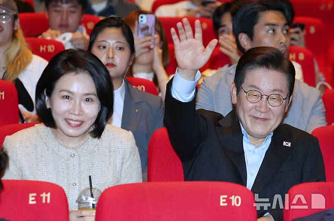 [부산=뉴시스] 최동준 기자 = 이재명 대통령과 김혜경 여사가 20일 부산 해운대구 영화의전당에서 부산국제영화제 공식상영작 '극장의 시간들' 관람에 앞서 관객들에게 인사하고 있다. (대통령실통신사진기자단) 2025.09.20. photocdj@newsis.com