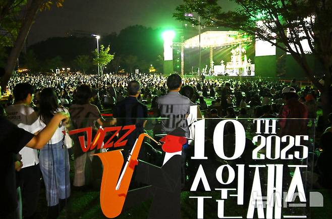 [수원=뉴시스] 김종택 기자 = 2025 수원재즈페스티벌 둘째날인 20일 오후 경기 수원시 광교호수공원 재미난 밭에서 잔디광장을 가득 메운 시민들이 선선한 가을 공기를 맞으며 흥겨운 재즈 선율을 즐기고 있다. 2025.09.20. jtk@newsis.com