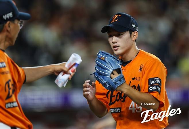 한화 윤산흠이 투구를 마친 뒤, 마운드에서 내려오며 김우석 코치와 하이파이브를 하고 있다. 사진 | 한화 이글스