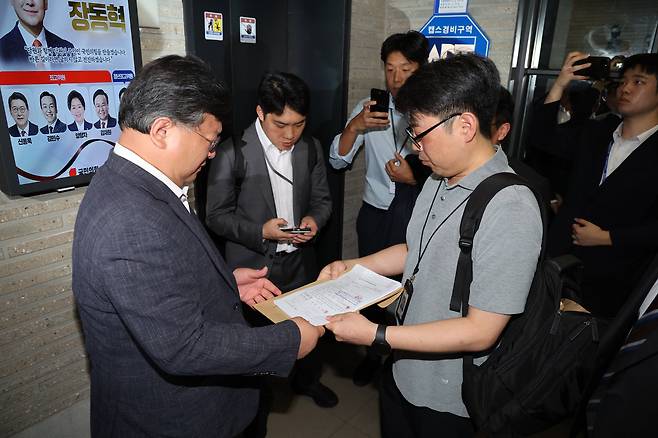 국민의힘 당원명부 압수수색에 나선 김건희특검 수사관들이 지난 18일 서울 여의도 중앙당사에서 국민의힘 변호사에게 영장을 제시하고 있다./뉴스1