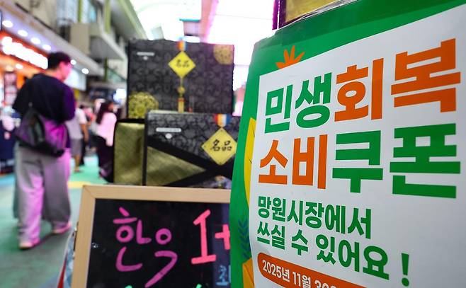 민생회복 소비쿠폰 2차 지급 신청일을 하루 앞둔 21일 서울 마포구 망원시장의 한 상점에 민생회복 소비쿠폰 사용가능 안내문이 게시돼 있다. 2차 소비쿠폰은 소득 하위 90% 국민에게 1인당 10만 원씩 지급되며, 온·오프라인 모두 신청 첫 주(9월 22~26일)에는 시스템 과부하와 주민센터 혼잡 방지를 위해 출생 연도 끝자리를 기준으로 요일제가 적용된다. 뉴시스