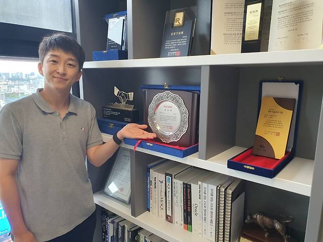 김찬중 팀장이 코스닥 상장패 등을 보여주고 있다. 윤현주 기자