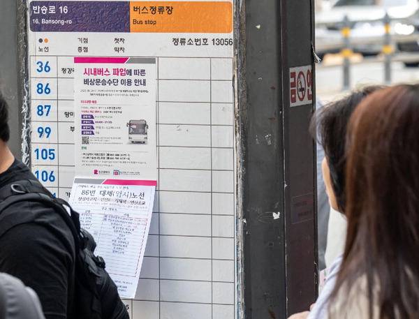 지난 5월 28일 부산 연제구 연산동 연산교차로 인근 버스정류장에서 시민들이 파업으로 인한 버스 운행 중단과 대체 수송 수단을 알리는 안내문을 읽고 있다. 국제신문 DB