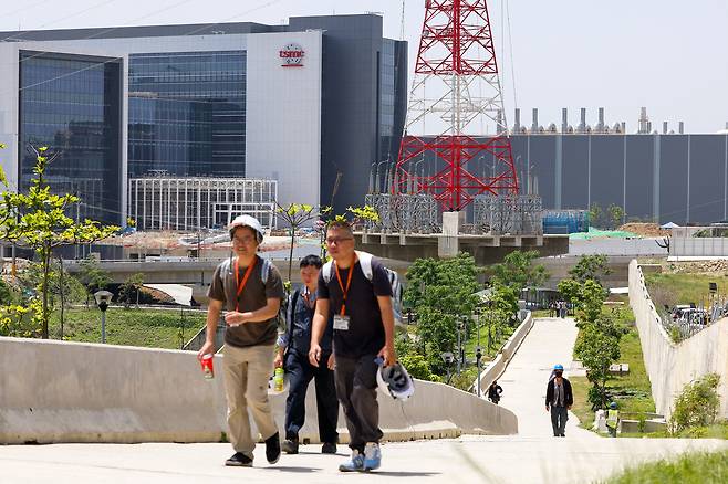 지난 4월 15일(현지시간) 대만 신주에 위치한 신주 과학공원에서 사람들이 TSMC 로고 앞을 지나가고 있다. [로이터]
