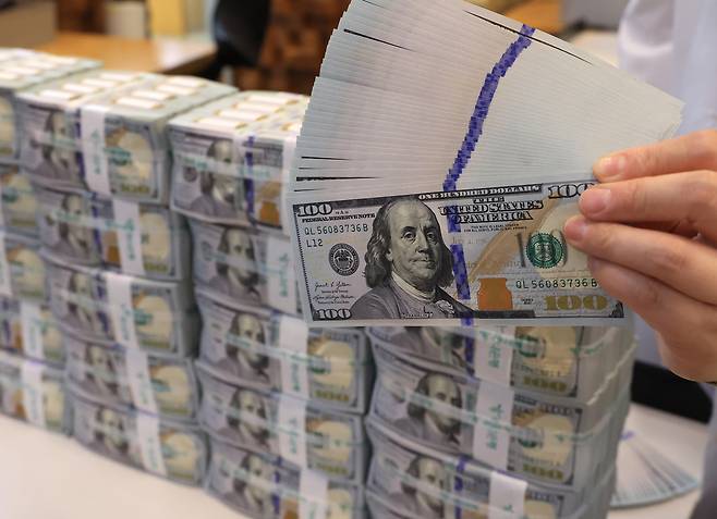 사진은 서울 명동 KEB하나은행 위변조대응센터에서 미국 달러를 들어 보이고 있는 직원 [연합]