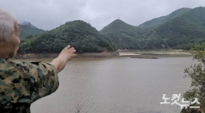 지난 20일 오후 오봉저수지를 찾은 한 시민이 저수지 안의 섬으로 불리는 말구리재를 바라보고 있는 모습. 전영래 기자