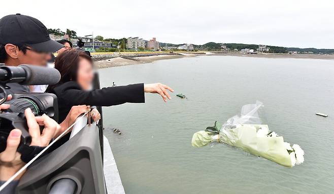 ▲ 지난 11일 인천 영흥도 갯벌에서 갯벌 고립자를 구하다 숨진 고 이재석 경사의 유족들이 사고 현장 인근을 찾아 바다에 흰 국화 꽃다발을 떨어뜨리고 있다./이재민 기자 leejm@incheonilbo.com&nbsp;