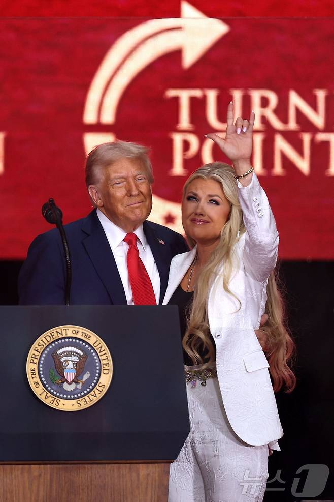 총격으로 숨진 우파 활동가 찰리 커크의 아내 에리카 커크가 21일 애리조나주 글렌데일에서 열린 추모 행사에서 도널드 트럼프 대통령과 끌어안은 뒤 하늘을 향해 손동작을 하고 있다. 2025.9.21 ⓒ AFP=뉴스1 ⓒ News1 강민경 기자