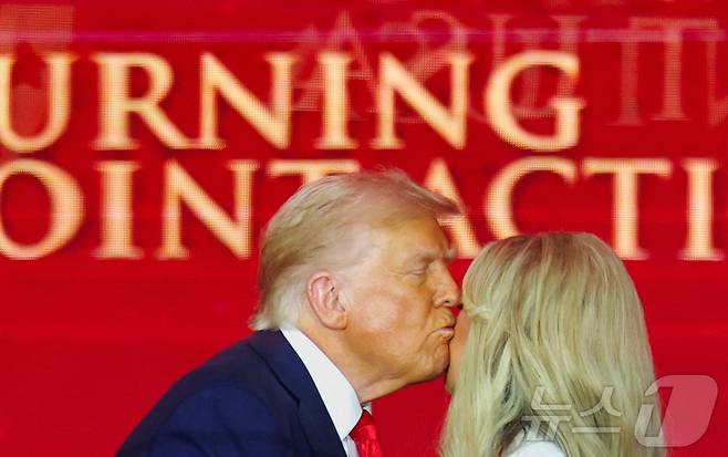 도널드 트럼프 미국 대통령이 21일 애리조나주 글렌데일에서 치러진 찰리 커크 추모 행사에서 그의 아내 에리카 커크의 뺨에 입을 맞추고 있다. 2025.9.21 ⓒ 로이터=뉴스1 ⓒ News1 강민경 기자