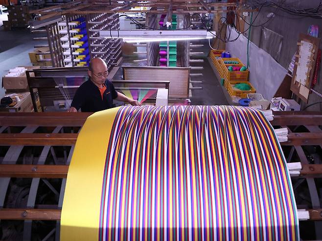 정경사 조건환씨가 지난 16일 충남 공주시 유구읍 동원직물 공장에서 색동 원단을 직조하기 위해 7가지 실을 정경기에 배열하고 있다. 백소아 기자 thanks@hani.co.kr