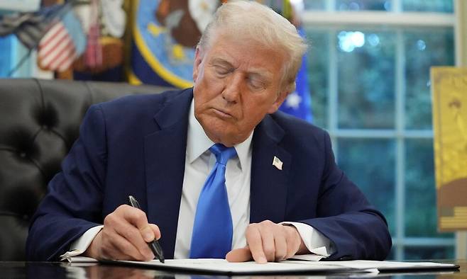도널드 트럼프 미국 대통령이 19일 워싱턴디시의 백악관 집무실에서 100만달러(약 14억원)를 내면 영주권을 준다는 내용의 ‘골드카드’ 비자 행정명령에 서명하고 있다. 로이터 연합뉴스