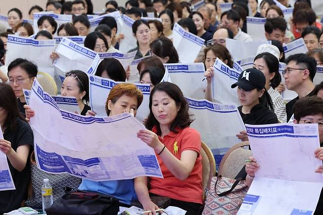 지난해 서울 광진구 세종대에서 열린 ‘종로학원 2025대입 수시, 정시 지원전략 특집 설명회’를 찾은 학부모들이 배치표를 비롯한 입시 자료를 살펴보고 있다. 한겨레자료