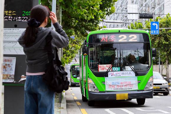 대중교통 환승할인 보전 규모를 놓고 서울시와 갈등을 빚고 있는 서울시마을버스운송사업조합이 22일 요구안이 수용되지 않으면 내년 1월 1일부터 환승제도에서 공식 탈퇴하겠다고 밝혔다. 사진은 서울 시내 버스정류장에서 한 시민이 마을버스를 기다리는 모습. [사진=연합뉴스]