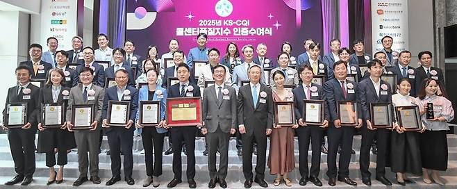 ‘2025년 콜센터품질지수(KS-CQI)’ 우수기업 인증서 수여식이 22일 서울 송파구 시그니엘서울에서 열렸다. 앞줄 왼쪽부터 김헌주 원장(한국건강증진개발원), 김민수 대표(시몬스), 임도곤 부사장(NH농협생명), 정민수 고객컨택영업그룹 대표(KB국민은행), 김새라 전무(LG유플러스), 박승표 대표(KT알파 쇼핑), 문동민 회장(한국표준협회), 서창적 이사장(건양교육재단), 주희주 상무(삼성전자서비스), 윤동인 상무(LG전자/하이텔레서비스), 이대진 대표(DBCNS자동차손해사정), 이종규 대표(SK텔레콤/서비스에이스), 권순희 부장(iM뱅크), 고은정 대표(LG유플러스/아인텔레서비스). [한국표준협회 제공]