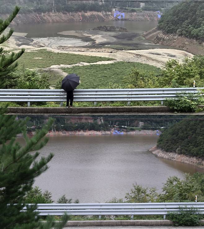 지난 17일 메마랐던 오봉저수지 모습과 21일  물이 차오른 오봉저수지 모습. 저수율이 50% 이상 오르면서 저수지 안의 섬으로 불리는 말구리재가 물에 잠겼다. 연합뉴스