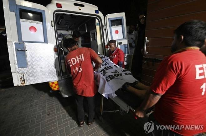 지난 21일 파키스탄에서 총기 피살된 트랜스젠더 여성 시신을 구급차에 옮겨싣는 구조대원들. EPA 연합뉴스