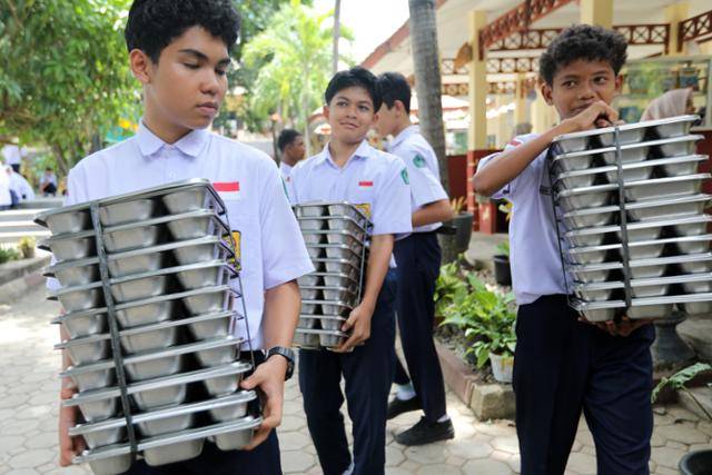 지난달 19일 인도네시아 아체특별자치주 반다아체의 한 중학교에서 학생들이 급식판을 옮기고 있다. 반다아체=EPA 연합뉴스
