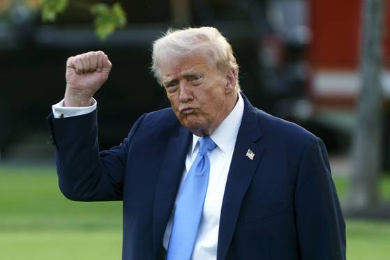 도널드 트럼프 미국 대통령이 22일(현지시간) 백악관에서 전용 헬기인 마린 원에 탑승하기 전 취재진을 향해 주먹을 쥔 채 인사하고 있다. EPA=연합뉴스