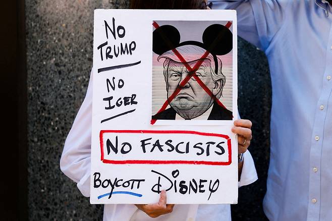 19일(현지시간) 미국 뉴욕 맨해튼의 ABC 스튜디오 앞에서 월트디즈니 산하 ABC 방송이 ‘지미 키멀 라이브!’ 프로그램을 폐지한 데 항의하는 집회 중 한 시민이 피켓을 들고 있다. 로이터연합뉴스