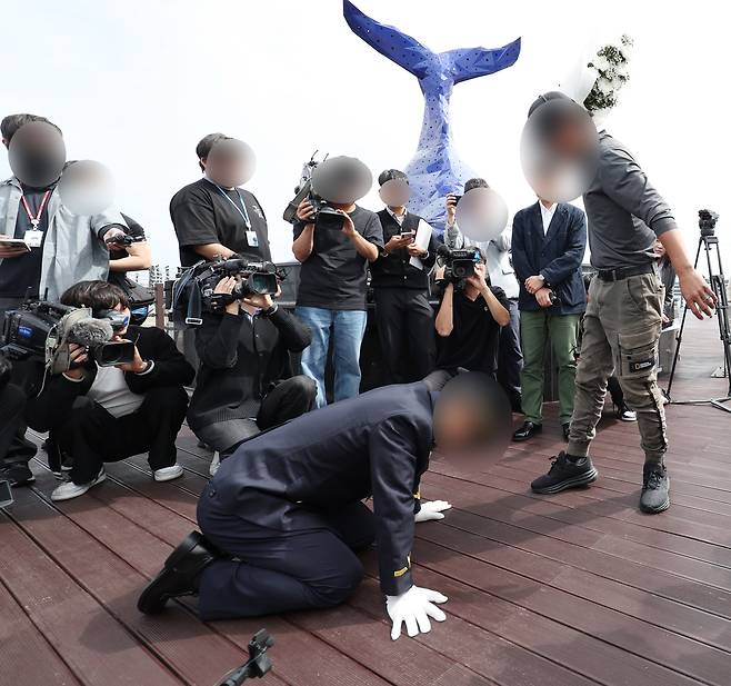 22일 오전 인천시 옹진군 영흥도 하늘고래 전망대에서 순직한 이재석(34) 경사의 파출소 당직팀장이 유족에게 무릎을 꿇은 채 사죄하고 있다. [연합]