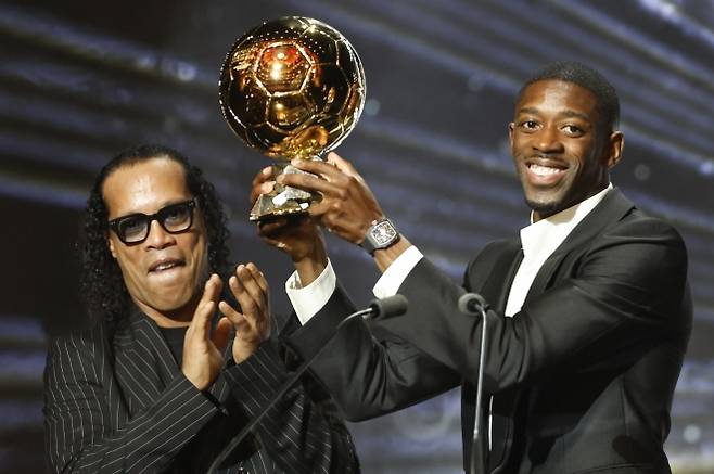 파리 생제르맹 우스만 뎀벨레가 23일(한국시간) 프랑스 파리 샤틀레 극장에서 열린 2025 발롱도르 시상식에서 2005년 수상자 호나우지뉴에게 남자 선수 부문 트로피를 받고 기뻐하고 있다. 파리 EPA 연합뉴스