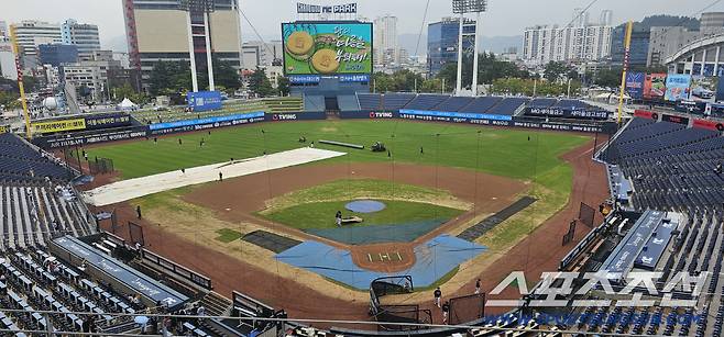 LG-NC전이 열릴 예정인 24일 창원NC파크에 비가 내리자 대형 방수포를 준비하고 있다. 창원=권인하 기자