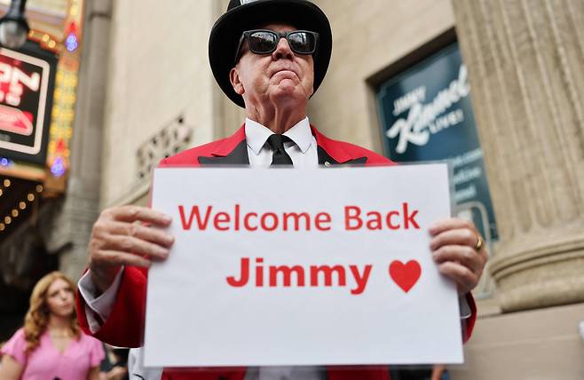 23일 캘리포니아주(州) 로스앤젤레스(LA)의 '지미 키멀 라이브!' 제작 스튜디오에서 방송 재개를 환영하는 한 시민이 관련 피켓을 들고 있다. /AFP 연합뉴스