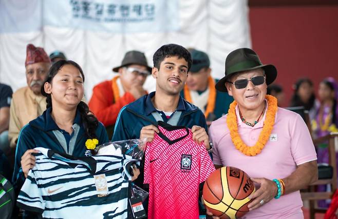 다목적 실내체육관 준공 기념으로 엄홍길 대장(오른쪽)이 네팔 학생들에게 한국 축구 대표팀 홈, 원정 유니폼과 농구공을 선물했다. 엄홍길휴먼재단 제공