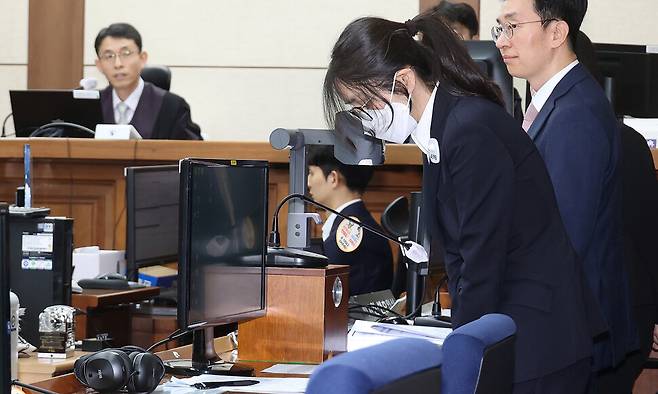 자본시장법 위반 등 혐의로 구속 기소된 윤석열 전 대통령의 부인 김건희 여사가 24일 오후 서울 서초구 서울중앙지법에서 열린 첫 공판에 출석해 자리에 앉기 전 고개를 숙이고 있다. 사진공동취재단