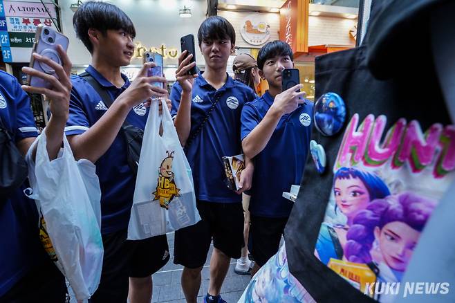 지난달 21일 서울 중구 명동 거리에서 일본에서 온 관광객들이 넷플릭스 애니메이션 ‘케이팝 데몬 헌터스’의 캐릭터처럼 꾸민 마네킹을 살펴보고 있다. 유희태 기자