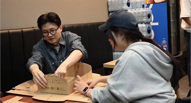 한동훈 전 국민의힘 대표가 23일 경남 진주 소재 치킨 프랜차이즈 가게에서 치킨 포장 박스를 접고 있다. 한동훈 전 국민의힘 대표 인스타그램 캡처